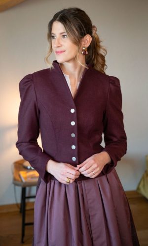 Dame in weinrotem Blazer mit passendem Dirndl dazu