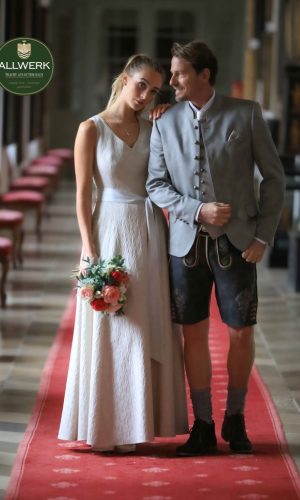 Kleid-Sissi-M-9519-94,H.Jacke-Starnberg-Q-9542-94,Weste-Belvedere-B-9569-93,Lederhose-Pernitz-1285-FB.28_mit-Logo_oben-links_web Hochzeitskleid in cremeweiß (lang);Herren Sakko in beige/grau und dunkler Lederhose (kurz)